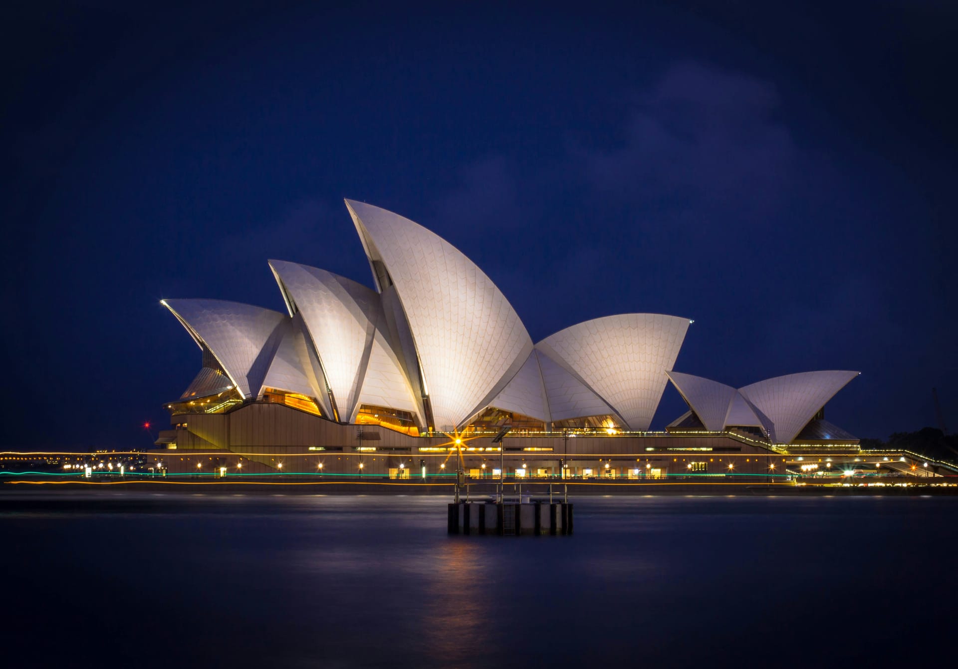 Sydney Opera House and Harbour Bridge at dusk with lights reflecting on Sydney Harbour