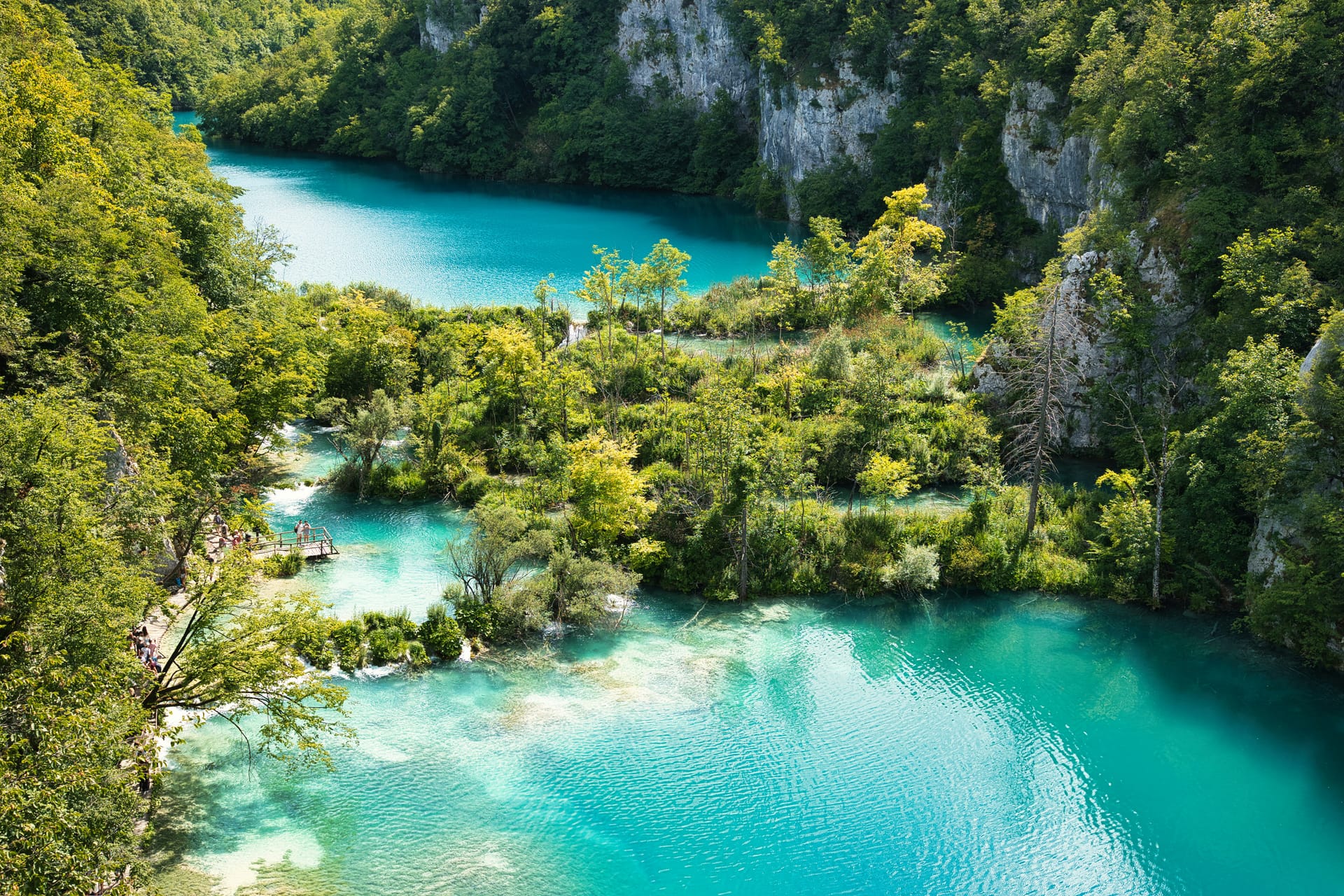 Wooden walkways crossing turquoise lakes and waterfalls in Plitvice Lakes National Park