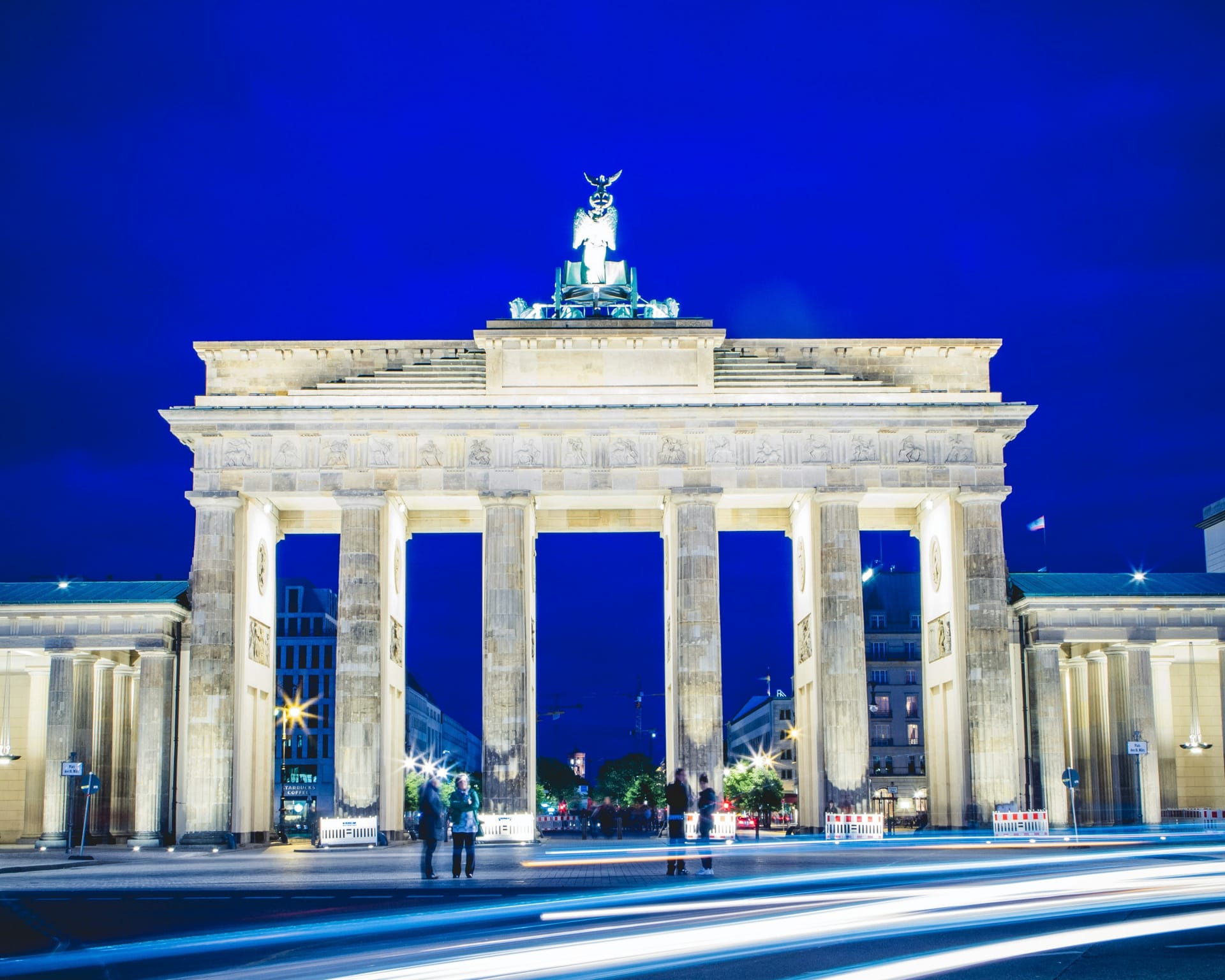 The Brandenburg Gate in Berlin at dusk, illuminated, with the Quadriga statue visible on top